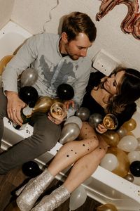 Messy Couples New Years Eve Photo Shoot in a bathtub with sparkling cider, balloons and confetti. New Mexico based portrait photographer, Crystal Cousin Photo.