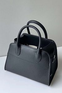 This bag is crafted with genuine leather and features the iconic design of The Row Margaux Leather Bag, with an internal logo stamp, open top with two top handles, buckle gusset detail, internal card slots, and internal zip-fastening pocket. The bag measures 26x17.5x21 cm.