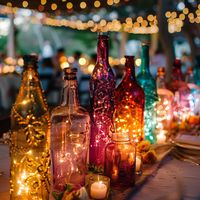 Add a touch of timeless elegance to your bohemian or vintage wedding with these enchanting centerpieces! 🌿 Transform ordinary tables into works of art by pairing vintage colored glass bottles with delicate fairy lights, casting a warm and inviting glow. 💫 Let the soft hues of the bottles and the twinkling lights transport you and your guests to a bygone era of romance and beauty. 🌸 Embrace the allure of nostalgia and create unforgettable memories amidst the rustic charm of these exquisite arrangements. #VintageWedding #BohemianStyle #WeddingDecor 🌺 #Ad#Promotion