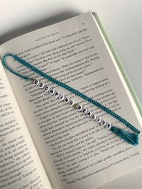 Introducing the Macramé Beaded Bookmark - the perfect blend of craftsmanship and functionality! This handmade macramé beaded bookmark adds a pop of fun to your reading routine. Slip it between the pages of your favorite book, journal, or planner. Each bookmark is handcrafted. The intricate macramé knotting technique, combined with carefully chosen beads, creates a one-of-a-kind piece of functional art. Beyond its aesthetic appeal, this bookmark is designed to withstand everyday use. The sturdy construction ensures it can endure the rigors of frequent page-turning while maintaining its charm. Searching for a thoughtful gift for the book lover in your life? Look no further! The macramé beaded bookmark makes a delightful present for birthdays, holidays, or just because. Personalize it with th