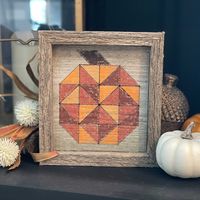 Put this adorable little wooden quilt block in your sewing room, living room, favorite shelf -- anywhere! Made from reclaimed pine, the pumpkin quilt block design is lasered onto the wood, then hand painted with acrylic paints. The 1 inch frame made from the same reclaimed wood allows the quilt block to easily sit on a shelf. Dimensions: approx. 6.5" x 7" x 1" deep frame Paint Colors: various oranges and brown. Colors and wood grain/texture will vary slightly from photos shown as each unique quilt block is created and hand painted upon order. Please allow approx. 2 weeks for this item to be custom made and shipped out to you.