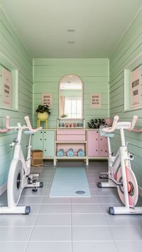 Brighten your exercise routine with this pastel-themed home gym! 🌼 Light mint green walls, pastel-colored dumbbells, and a white bike with pink handlebars create a cheerful and inviting space. The large window, soft gray flooring, and motivational prints make every workout a pleasure. 🌸 #PastelDecor #HomeGymDesign