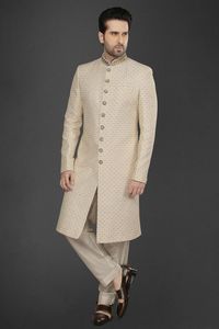 Impressive look in this beige color wedding and groom wear silk sherwani. Embellished with resham work at all over. Featuring with stand collar, full button placket, full sleeves, welt pocket, and vented hemline. Comes with aligarhi pant.