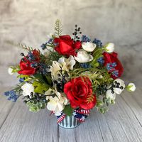 The patriotic colors of this farmhouse garden inspired  artificial floral arrangement is perfect for summer! An assortment of traditional colors including red, white, and blue make this piece perfect for Memorial Day, Fourth of July, and Labor Day. Its festive seasonal colors would add some flair to your summertime gatherings, whether it be a party or a barbecue. Professionally designed in my Central New York studio using faux florals in on-trend colors including: red roses, cream hydrangeas, wh