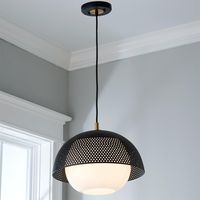 Modern design takes center stage with the perforated black metal dome and satin brass details of this pendant. The opal glass globe provides diffused lighting in any setting.