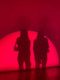 Friends, girlfriends, shadows, wall, red light, red room, modern art