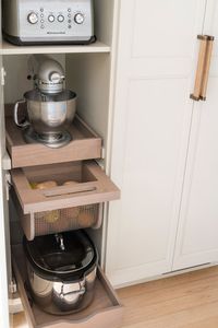 This appliance garage features pull-out shelves that can hold a toaster, mixer, crock pot, and more. Plus there is a pull-out produce drawer to keep vegetables hidden but fresh. Under the microwave, there is a hidden drawer with more storage for bread and rolls. 