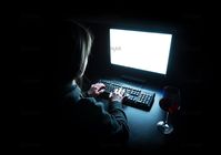 Photo Silhouette of woman typing at computer in dark illuminated by screen Image #10620542