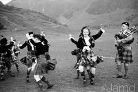 7th May 1955: Scotland's most famous highland dancing teacher, Jean Reynolds, performing a Scottish dance in traditional dress, to the tune of piper Hugh MacPherson. Jean Reynolds wears the black, yellow and red MacLeod tartan, claiming descent from the famous Gaelic singer, Roderick MacLeod.