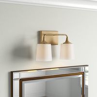 This 2-light vanity fixture aims to brightness your morning and evening routine while anchoring your bathroom with a luxe look. Rated for use in damp locations, this metal light features a square backplate, a curved, horizontal arm, and flared accents with a shiny or matte-style finish of your choice. A duo of white frosted glass shades rounds out this design, diffusing the light from compatible bulbs in an up or down direction thanks to its reverse-mounting feature. Plus, we love that it works