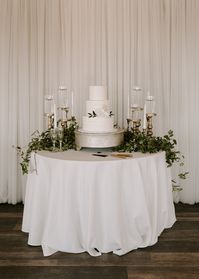 Champagne cake stand, off white linen in front of white curtain wall