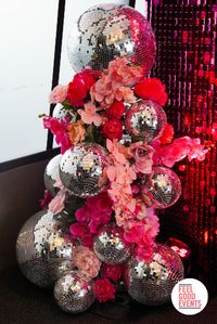 A dreamy pink & silver disco themed party setup for an end-of-year party featuring florals, mirror balls, and themed centrepieces 🪩🪩💖