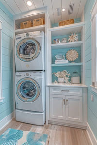 The Coastal Vibes Stacked Laundry brings the serene and laid-back feel of the beach into your home. Soft blues and sandy hues dominate this stacked laundry room, complemented by seashell and seaside decor. The use of natural textures like wicker for baskets and linen for curtains enhances the coastal theme. This design is perfect for those who wish to combine functionality with a relaxing, holiday-inspired feel. Light, flowing fabrics and coastal artwork complete the look, making laundry tasks more enjoyable. Tap to learn how to infuse your laundry room with coastal vibes.