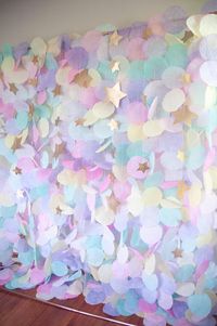 This gorgeous pastel paper garland backdrop would be a stunning accent for birthdays, weddings, or any other special occasion. This airy garland captures light beautifully to create a whimsical backdrop for any event. The display features a mixture of pinks, purples, yellows, and