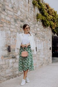 Ein T-Shirt – sechs Looks: Outfit mit T-Shirt, weißer Jeansjacke, Midirock mit Blumenmuster, rosa Chloé Nile Bag und Stan Smith Sneakers