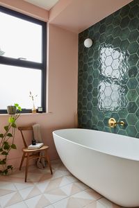 Green Hexagon Bathroom Accent Wall Tiles with White Freestanding Bathtub he use of opposing colors—in this case, pink and green—is a great approach to achieving the cheerful, quirky ambiance you want for your bathroom!