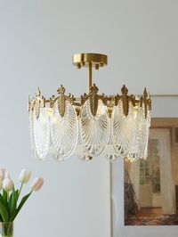 Hand-formed glass petals with Clear tints make up the frame in Vakkerlight's opulent Decorative Pattern Glass Round Chandelier. Each petal is made from glass and features a gold finish, while golden frames are integrated throughout for a glimmering silhouette. It's made from iron and metal.   If you have any questions about our products, please contact us and we will get back to you within 24 hours.   Product Size   5 heads s ize: Dia 40cm x H 23cm /  15.7 x H 9.1     6 heads s ize: Dia 50cm x H