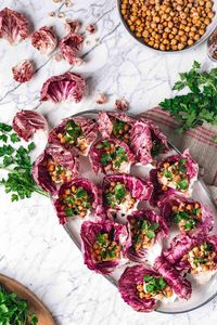 This hummus stuffed lettuce (or radicchio) chickpea wrap recipe is so quick & easy. A beautiful gluten-free vegan appetizer or everyday snack! These little wraps are a real crowd pleaser - so tasty and satisfying while fulfilling most dietary needs: vegan, gluten-free, oil-free, grain-free, refined sugar-free while being vegetable-forward and protein packed! #crispychickpeas #hummus #lettucewraps #vegan #glutenfree