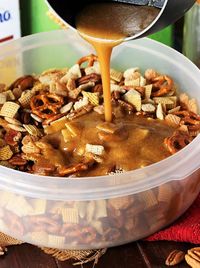 Pouring Brown Sugar Mixture Over Praline Party Mix Image