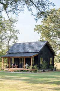 Small black barndominium with lush surroundings. Saddle up your creativity with simple barndominium ideas that blend rustic charm with modern comforts for a home that’s as practical as it is eye-catching.