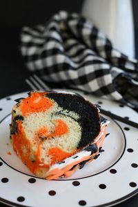 Easy Halloween Bundt Cake has orange, black, and white layers of cake with festive frosting! It's starts with a cake mix and a can of frosting! www.littledairyontheprairie.com #halloween #cake #halloweencake #orangeblackcake #easyhalloweencake #bundtcake #halloweenbundtcake #easyrecipe #holidays #baking #cakemix #halloweencakemix #halloweendesserts #dessert #tiedyedcake #halloweentiedyecake #blackfrosting #blackicing