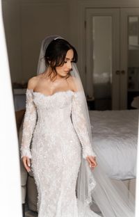 Inspired by Leah Da Gloria you can indulge in luxury and elegance with the C2024-LDG88 #wedding gown. With its off the shoulder design and long sleeves, adorned with intricate beaded lace, you will feel like a true queen. The cathedral train adds a touch of grandeur to this already stunning piece. Make a statement on your big #weddingday with this exclusive gown. #Brides can also email us #photos of their dream #weddingdress and we can easily make an inspired recreation of that #dress #design fo