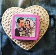 Perfect for the funkiest bride-to-be or for the hopeless romantic in many of us! I attached this bridal lenticular on top of buckles and a button to create this one-of-a-kind brooch! The image changes just a little to show the couple having a kiss. This large pin is made of vintage pieces that may show signs of wear. Grab this unique creation while you can! Comes with heart-shape box (pictured).