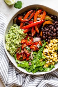 these easy & healthy grilled veggie burrito bowls are loaded with flavor! grilled peppers, onions, & sweet corn get paired with black beans & served with green rice - brown rice that’s tossed in a creamy avocado sauce. move over chipotle! wholesome, plant-based, naturally vegan & gluten-free, & meal prep-friendly! & #playswellwithbutter #veggieburritobowl #healthyburritobowlrecipe #easyrecipe #healthyrecipe #mealpreprecipe #grilledvegetables #greenrice #vegetarian #plantbased #vegan #easyvega...