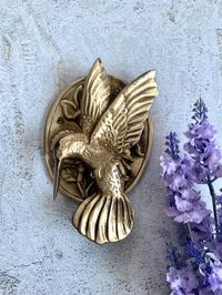 This exquisite Brass bird-shaped door knocker is the perfect addition to your door, giving it a distinct and remarkable look. The knocker and the plate are meticulously crafted with intricate details, showcasing the exceptional craftsmanship of the artist.  This door knocker is not just a beautiful work of art, but also a testament to its exceptional quality and durability. It's made to last, withstanding the test of time, making it an ideal gift for your loved ones. Product measurement details: