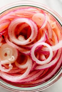 This tangy, crisp, IRRESISTIBLE quick-pickled onion recipe is ready in 30 minutes! #pickledonions #Mexicanrecipe #pickledonionrecipe