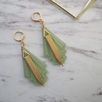 If Characterized by bold shapes, eye catching geometry, elegant color schemes and satisfying symmetry, art deco is too beautiful a design style to stay on the walls. Bring the appeal of this chic and classic aesthetic to your daily life with the Jaded Moon Art Deco Dangle Earrings. Elegance dangling from your ear lobes. This set of earrings features a backdrop crafted out of high quality acrylic made to resemble jade stone that is carved into the angle that defines the style. Overlaying the jade area is a gold-plated charm that lines up beautifully with the shape of the jade, giving it its iconic art deco appearance.   These Jaded Moon Art Deco Dangle Earrings  are crafted out of high quality materials from end to end, including the gold-plated posts. Each pair is super lightweight, making