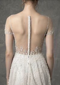 The Serena wedding dress has a short sleeve illusion neckline with sweetheart lining, beaded bodice and A-line skirt with whimsical vine like beading throughout and buttons down the center back. #wedding #weddingdress #weddingideas #weddingplanning #weddingdressstyles #shortsleeveweddingdress #shortsleevedweddingdress #weddingdressinspiration #weddinginspiration