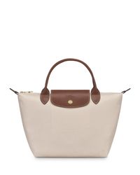 In a miniature size, Longchamp's signature nylon tote lends sophisticated style to every look. The lightweight design folds up for ease during travel.