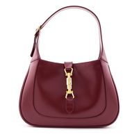 A classic Gucci silhouette in a minimalist polished finish, this Jackie 1961 Hobo is a staple you'll love for many years to come! The smooth deep red calfskin exterior offers rounded corners and a structured build with a semi-rigid flat leather top handle for carrying in hand or on shoulder. An included strap extender provides the option to wear this authentic preloved Gucci bag across your body. The monochromatic exterior secures with a high contrast logo-engraved gold-tone piston lock closure,