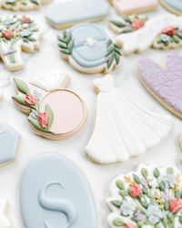 This photo stopped me in my tracks while I was scrolling through the dozens I took of this set (anyone else take WAY too many photos of every set 😅). It’s a different angle and most of the cookies are out of focus, but I love it! Swipe for a photo of the full set in a more traditional photo! This bride in bloom wildflower bridal shower cookie set was so fun to create! Their main wedding color is dusty blue so I focused on that and added in some of the floral tones from the invite. If you want...