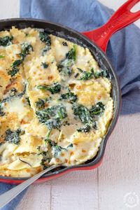 This Baked Spinach Ravioli Bake can be made and served in one skillet.  Bonus, it can be on the table too in 30 minutes! #pastabake #skillet #ravioli #cheesy