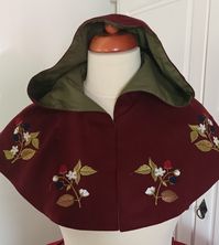 The cape is sewn from wool Fabric, lined with cotton canvas. Decorated with machine embroidery. The front part closes with hooks and eyelets Fits perfectly with a fantasy costume. The color is dark burgundy with a green lining