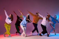 Modern hip hop dancer frozen in movie, standing on tiptoe, covering head with hands, expressing dance element, practicing in dance studio, full of energy break dancer - Buy this stock photo and explore similar images at Adobe Stock | Adobe Stock