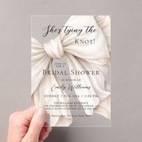 A gorgeous acrylic bridal shower invitation with the popular theme "She's tying the knot!", this design features a large ivory white watercolor bow angled across the invitation in charming coquette style. A text template is included to personalize with your event details. Celebrate the bride in glamorous modern style with this feminine bridal shower invitation.