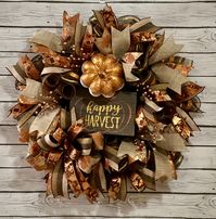 This beautiful Fall wreath is the perfect addition to your fall decor. The wreath has a Happy Harvest sign with a  copper glittered white pumpkin to welcome all your guests this Fall season. The wreath is a thin wreath, with loads of designer fall ribbon tails. coppers and browns are the main colors and copper berry picks accent the wreath. A big beautiful bow completes the look.  Ribbons may need to be straightened after unpacking. Wreath will be packed with care.  Ships within 1-3 days.  This wreath would look great on your door, front or back porch or in your home.  Deco mesh is durable for outside use but a protected location will prolong the life of your wreath. Clear coat and UV protection sprayed.  It will be shipped in a large box that will also be a great place to store your wreat