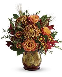 Celebrate the season with the hearth-inspired hues of this lush autumnal bouquet, arranged in an amber glass lantern with metal handle and golden leaves. Lovely as a vase or candleholder!  Orange bi-color roses, bronze disbud chrysanthemums, and rust daisy spray chrysanthemums are arranged with parvifolia eucalyptus, lemon leaf, red oak leaves, and natural wheat. Delivered in a Citrus Harvest lantern.  #wildflowers #fallflowers #October2018 #orangeroses #localflorist #wallnj #monmouthcounty #sh…