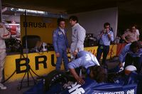 Patrick Depailler and Jody Scheckter look on as mechanics work on Scheckter's Tyrrell 007 Ford.Red Bull Ring, Austria, August 17, 1975.