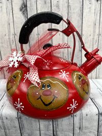 Handpainted gingerbreads and snowflakes on a red tea pot.