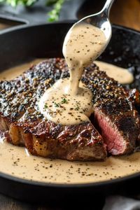 Savor a perfectly seared Bavette steak cooked in a cast iron skillet, topped with a rich whiskey garlic cream sauce for an indulgent, meal.