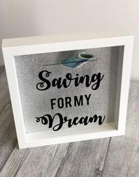 Saving for my Dream Money Box White Money Box Frame measures around 23cm x 23cm Silver glitter Background - Other colour options tooBlack Lettering saying 'Saving for my Dream'Makes a Great Gift and Present!Perfect way to save