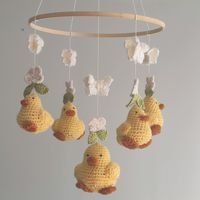 Elevate your nursery decor with this enchanting crochet baby mobile featuring four delightful yellow ducks. Each duck is meticulously handcrafted in the United States, showcasing intricate details that make it a stunning piece of art. Adorned with charming white flowers and butterflies, these soft, cuddly ducks are designed to soothe your little one to sleep, creating a serene atmosphere in any baby's room. Made from high-quality, non-chemical wool, this mobile not only looks beautiful but also ensures a safe and gentle touch for your baby. This unique nursery mobile is more than just a decorative piece; it's a heartfelt gift that will be cherished for years to come. Perfect for baby showers, birthdays, or as a special treat for your little one, this mobile is a must-have for anyone who ap