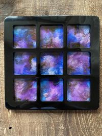 This beautiful inked board game is a showpiece of the possibilities of resin. The base is deep black with a glorious ink splashed foreground in blue,purple and gold. Each of the nine panels are outlined in black, drawing attention to the beautiful waves of color inside. At 8 inches, these boards are large and easy for kids and adults alike to use. Comes with a total of 10 game pieces.  This item is made from high quality, heat-resistant epoxy resin. It is light weight and damage resistant.  Note