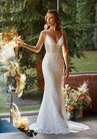 Geometric fitted lace bridal gown with v-neck and v-back. Sampled in bridal size 12, in ivory (color pictured). Can be ordered in sizes 2-28, in ivory only.