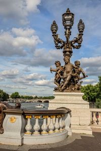 This angelic bronze sculpture adorns the most ornate bridge in Paris, France. The Pont Alexandre III is a deck arch bridge that spans the Seine and is classified as a French historical monument since 1975. This image was taken on a bright spring day and features one of the bronze angels at the ends.