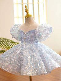 This princess flower girl dress in dusty blue is fit for a royal occasion. With its sequined design and short lantern sleeves, your little one will shine like a true princess. The back zip makes dressing easy, while the tea length adds a touch of elegance. Perfect for baptisms or other special events.